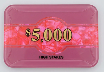 A pink high-stakes gaming chip tray or card with a marbled pink and orange center band featuring the text '$5,000' in gold, and 'HIGH STAKES' printed in black below, shown on a light gray background.