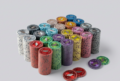 A collection of colorful poker chips arranged in stacks and on a light gray background. The chips come in multiple colors including red, green, purple, pink, yellow, blue, black, and white, with some standing upright in stacks and others lying flat.