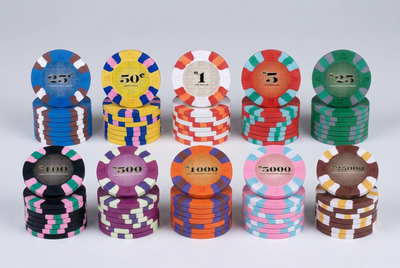 A set of ten casino-style poker chips arranged in two rows on a light gray background. The chips come in multiple colors and denominations, including 25, 50, 1, 5, 25, 500, 1000, 5000, and 10000.
